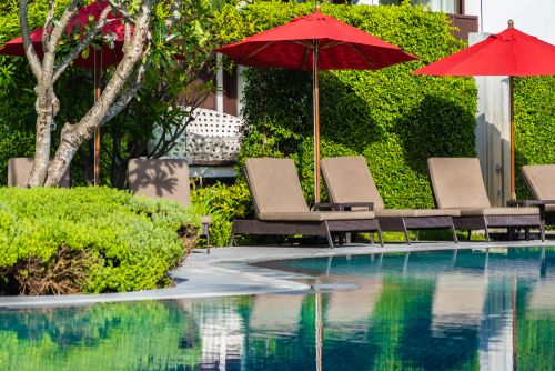 home pool with chairs and umbrellas in summer